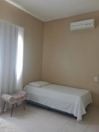 1 dormitorio con cama blanca y ventana en Casa Raios de Sol, en São Raimundo Nonato