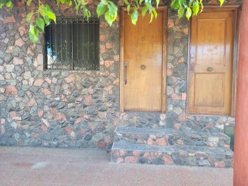 um edifício de pedra com uma porta de madeira e um banco em HERMOSO APARTAMENTO MONOAMBIENTE ZONA SHOPPING em Colonia Mariano Roque Alonso