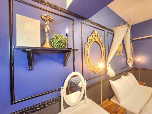 a room with blue walls and a white couch and a mirror at 一中喵喵 有統編收據 禁菸 非自助 in Taichung