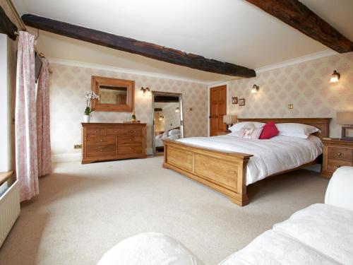 a bedroom with a large bed and a dresser at The Farmhouse - Uk4188 in Hazlehead Bridge