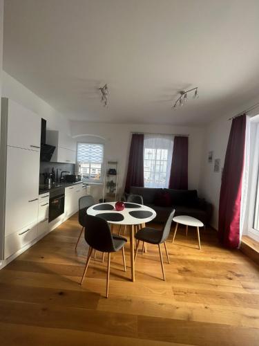 a kitchen and living room with a table and chairs at CityLake G23 Apartments mit kostenloser Parkmöglichkeit !! in Gmunden