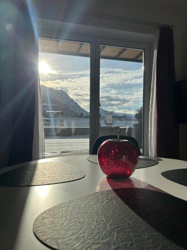 a red bowl sitting on a table in front of a window at CityLake G23 Apartments mit kostenloser Parkmöglichkeit !! in Gmunden