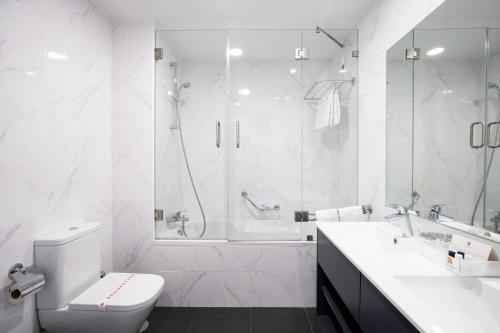 uma casa de banho branca com uma banheira, um WC e um lavatório. em Hotel Fatima em Fátima