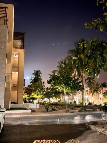 a night view of a building with palm trees at Hawana salalah Apartment in Salalah