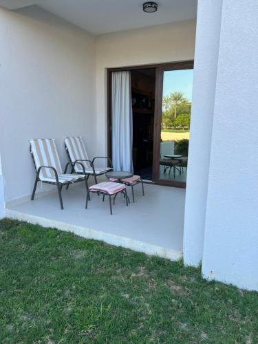 2 chaises assises sur la terrasse couverte d'une maison dans l'établissement Hawana salalah Apartment, à Salalah