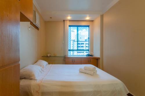 una camera da letto con un letto e due asciugamani di Apt Lindíssimo com Piscina e Climatização a Salvador
