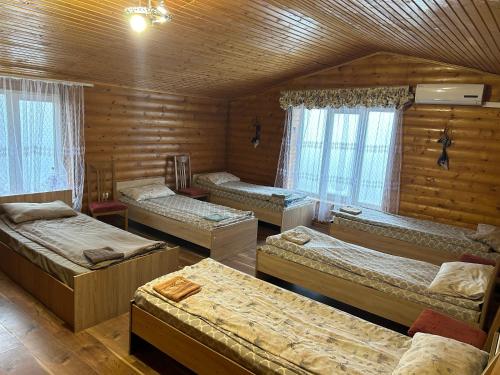 a room with four beds in a log cabin at Готель Максим in Drogovyzhe