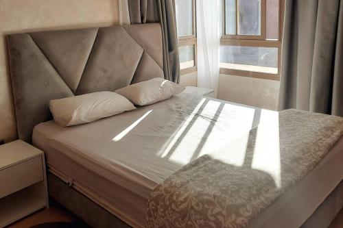a bed with two pillows on it with a window at Prestigia Jade Marrakech in Marrakech