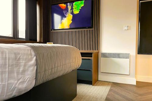 um quarto com uma cama e uma televisão na parede em Deluxe 1 Bed Studio 4C near Royal Infirmary & DMU em Leicester