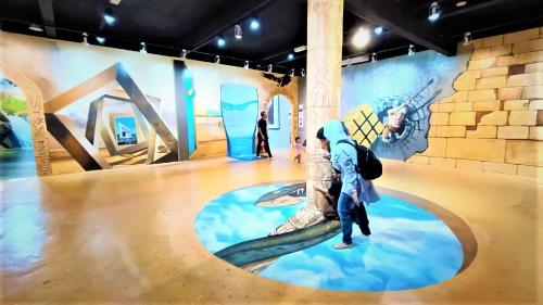 a person standing in a room with a painting on the wall at BY LG Water Themepark Facilities & Suites By GGM in Melaka