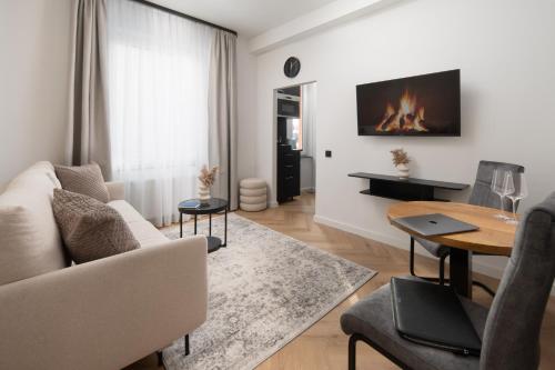 - un salon avec un canapé et une table avec une cheminée dans l'établissement Wohnung 'The Cove' HBF/Messe/ÖVB Arena/City, à Brême