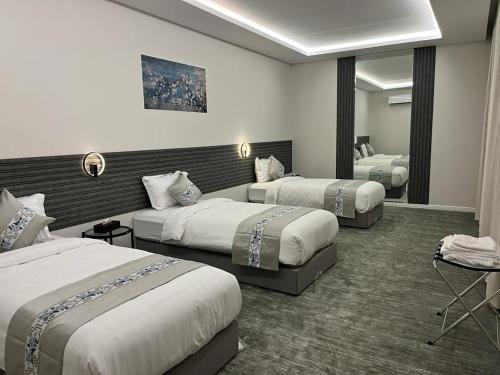Habitación de hotel con 2 camas y espejo en فيلا ساره en Medina