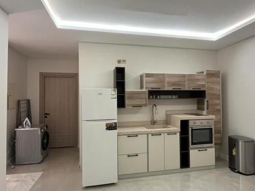 uma cozinha com um frigorífico branco num quarto em فيلا ساره em Al Madinah