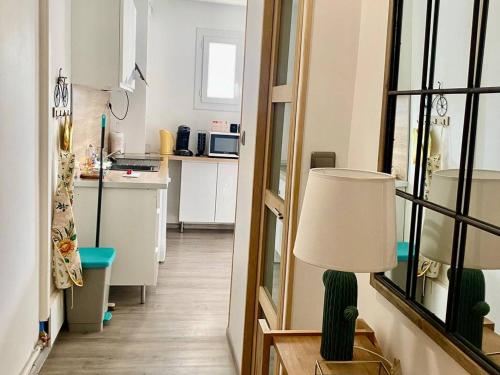 un salon avec une lampe et une cuisine dans l'établissement Appartement F2 avec terrasse, proche centre et cures - Amélie-les-Bains - FR-1-703-41, à Amélie-les-Bains-Palalda