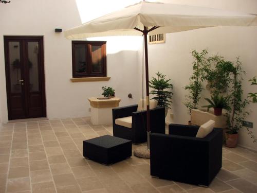 d'une terrasse avec un parasol, des chaises et des toilettes. dans l'établissement B&B Corti Carmela, à Gallipoli