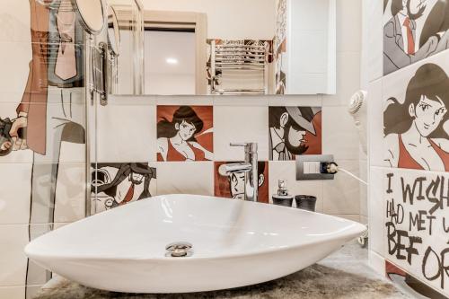 a white sink in a bathroom with pictures on the wall at Casa Casu in Rome