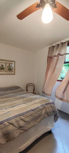 a bedroom with a bed and a ceiling fan at Apartamento pé na areia com vista para o Mar de Itaipu in Niterói