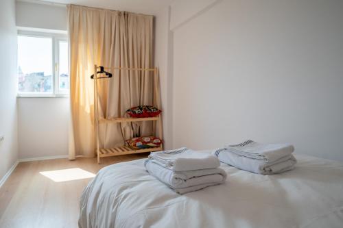 Habitación blanca con cama y toallas. en Nomado Residence with gym, en Estambul
