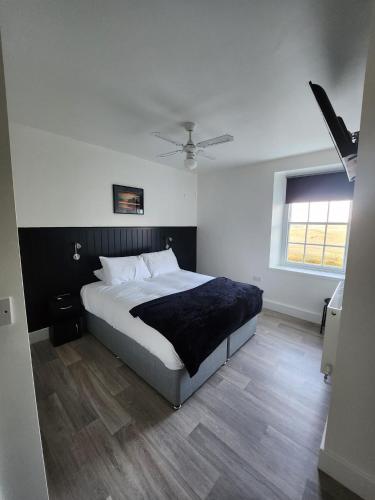 a bedroom with a large bed and a window at The Dock Hotel in Amble