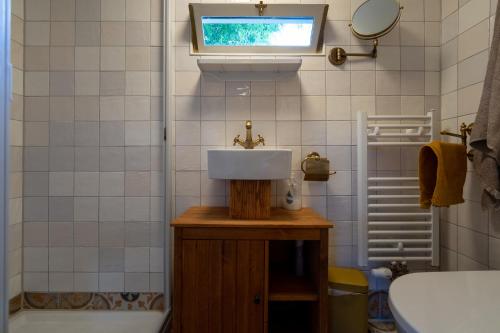 a bathroom with a sink and a tub and a window at De Wagen in Egmond-Binnen