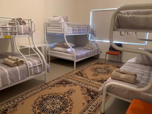 a room with bunk beds and a rug at Ocean Vista Beach Stay in Rockingham