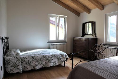 1 Schlafzimmer mit 2 Betten, einer Kommode und einem Spiegel in der Unterkunft La Pezzuola 52 in Sopralacroce