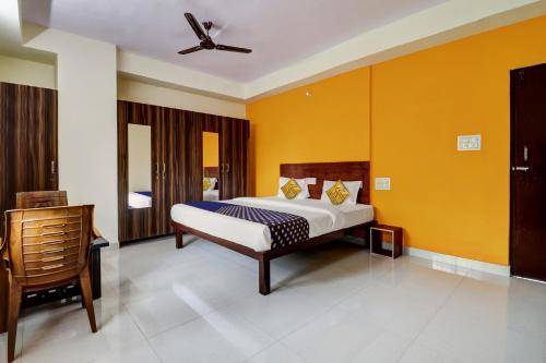 a bedroom with a king sized bed and yellow walls at SPOT ON Hotel Aaradhya Inn in Bangalore