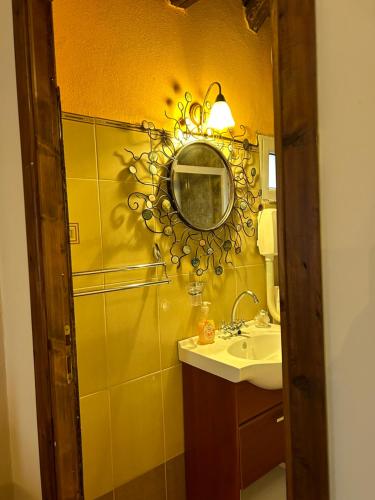 a bathroom with a sink and a mirror on the wall at Ξενώνας Θόλος Βαλτεσινίκο in Valtessiniko 