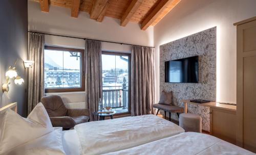 a hotel room with a bed and a balcony at Hotel der Wiesenhof in Pertisau