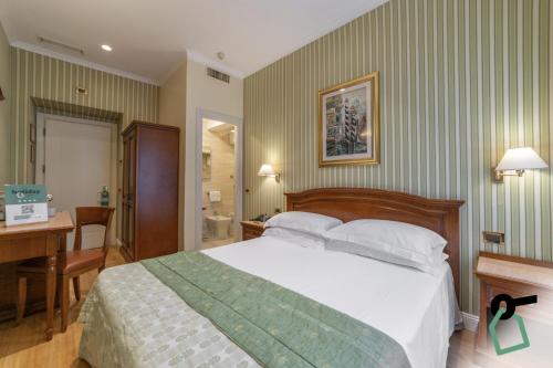 a hotel room with a bed and a desk and a desk at HOTIDAY Room Collection - Roma Porta Pia in Rome