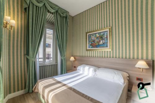a bedroom with a bed with green striped walls at HOTIDAY Room Collection - Roma Porta Pia in Rome