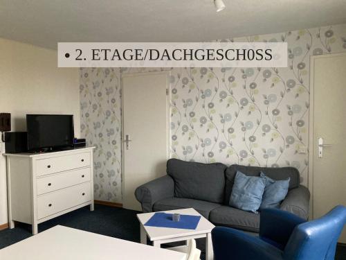 a living room with a couch and a sign that reads intense diabetes at Krabbe Apartment 10, zentral gelegen neben Muschel-und Krabbenmuseum, bis zu 2 Hunden kostenfrei willkommen in Wremen