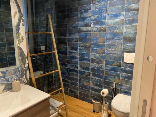 uma casa de banho com WC e uma parede de azulejos azuis em Eutierra BLeisure Stay em Roma