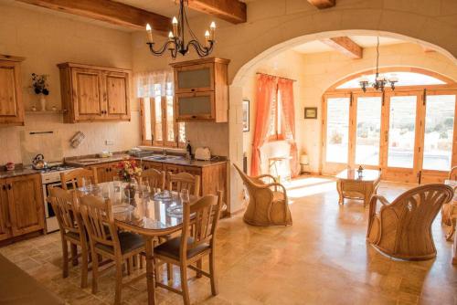 a kitchen and dining room with a table and chairs at Ta Marie Farmhouse, Ghasri Gozo in Għasri