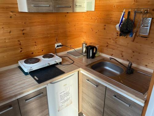 a small kitchen with a sink and a stove at Bungalow WALD & SAND direkt am Strand in Dranske