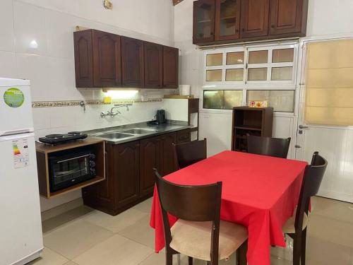 eine Küche mit einem Tisch und einem roten Tischtuch darauf in der Unterkunft Casa Pellegrini in Posadas