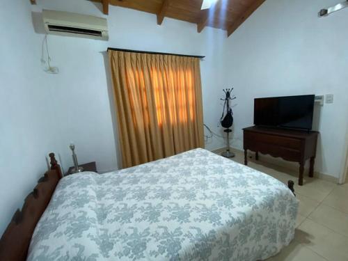 ein Schlafzimmer mit einem Bett, einer Kommode und einem TV in der Unterkunft Casa Pellegrini in Posadas