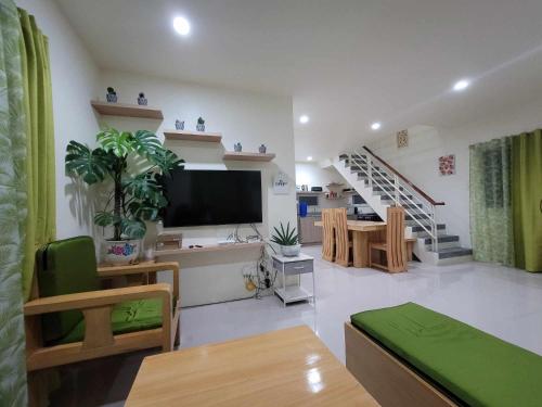 a living room with a flat screen tv and a staircase at New Tropical Inspired Home in Cagayan de Oro