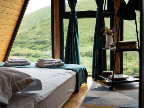 um quarto com uma cama e uma grande janela em Focus Point Drakhtik - Green Cabin em Drakhtik
