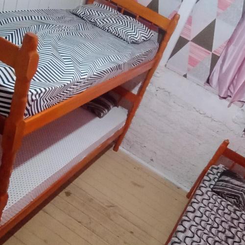 Ce lit superposé se trouve dans une chambre à côté d'une chaise. dans l'établissement Hostel formigueiro, à Imbituba