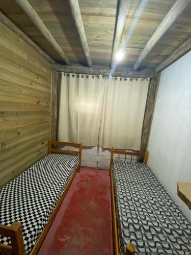 Habitación con 2 camas en una habitación con ventana en Hostel formigueiro en Imbituba