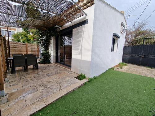 un cortile con tavolo e un patio con prato di Chez Lilo a Fos-sur-Mer