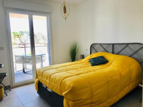 - un lit avec une couverture jaune dans une chambre dans l'établissement Appartement Résidence Coté Mer Calvi, à Calvi