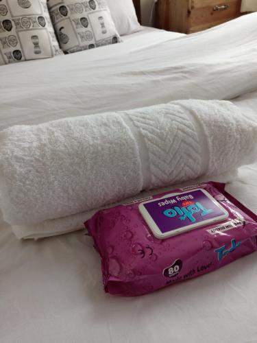 a towel on a bed with a thermometer on it at Serene Palace in Nairobi