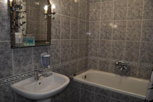 a bathroom with a sink and a bath tub at DayFlat Apartments Kremenchug in Kremenchuk