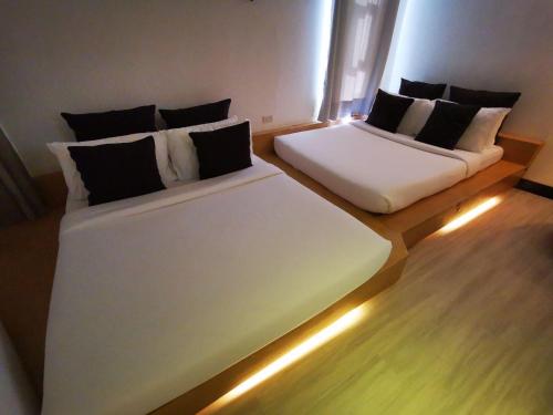 two beds in a room with lights on the floor at Urban Boutique Hotel in Boracay