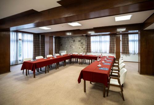 a large dining room with red tables and white chairs at Hotel Fatima Center in Fátima
