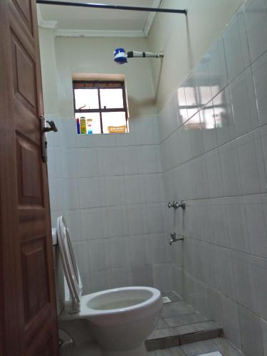 a bathroom with a toilet and a window at Serene Palace in Nairobi