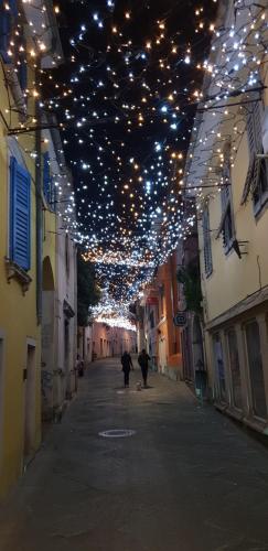 an alley with lights and people walking down a street at Hostel Museum in Koper