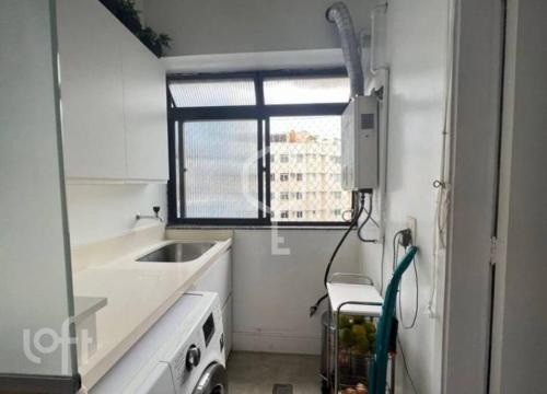 a white kitchen with a sink and a window at Excelente Apartamento no Leblon 02 quadras da praia em prédio com piscina, sauna e academia in Rio de Janeiro
